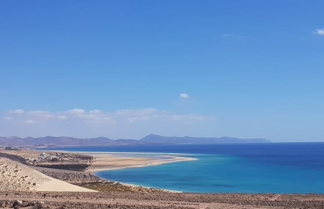 A Beachside With Clear Skies And Blue Water