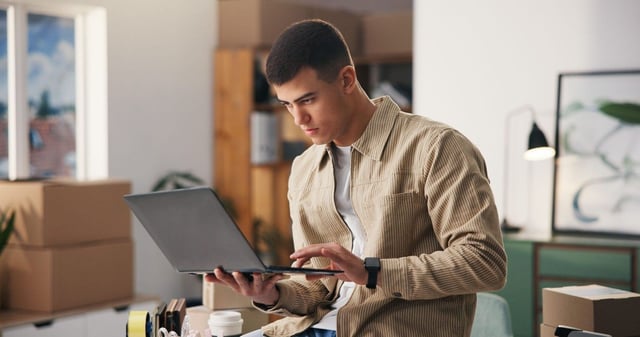 A Young Man Attentively Looking At The Laptop Screen