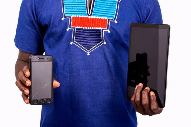 African Man Showing A Smartphone And Tablet