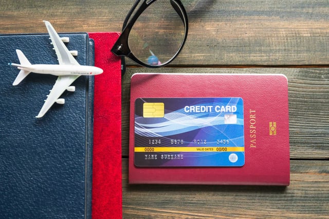 Credit Card Placed On A Passport On A Wooden Desk