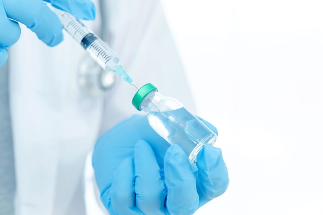 Doctor preparing vaccination syringe