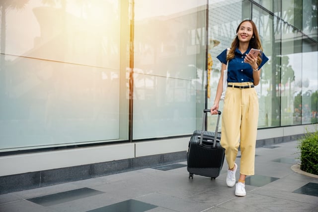 Female tourist with luggage outside building