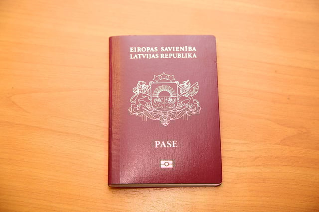Latvian Citizen's Passport On The Table Of Red Color