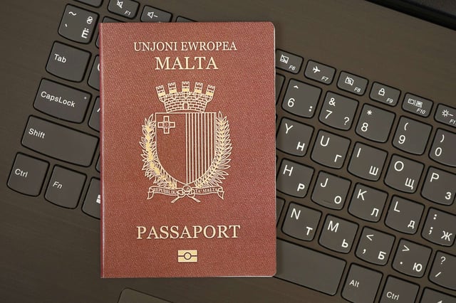 Malta Passport Lies On Black Laptop Keyboard Buttons Background