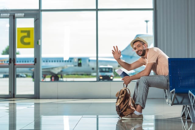 Man Waving To Someone In Airport