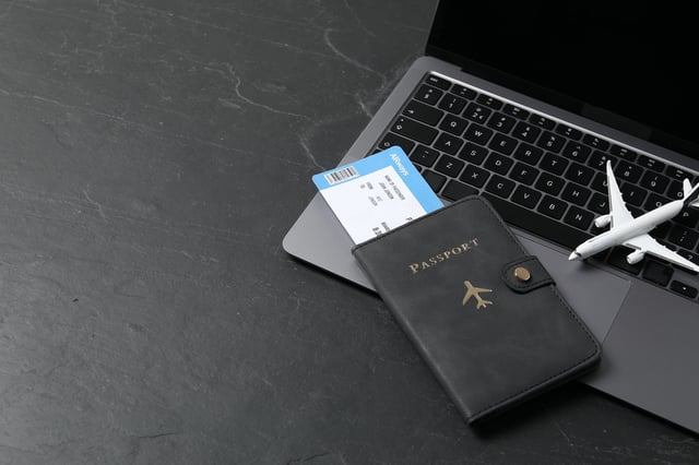 Passport Flight Ticket Plane Model And Laptop On Black Table