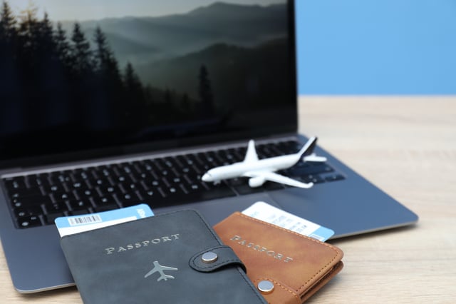 Passports Flight Tickets Plane Model And Laptop On Wooden Table