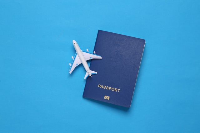 Toy Passenger Plane And Passport On Blue Background
