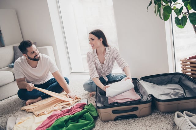 Two people packing clothes together