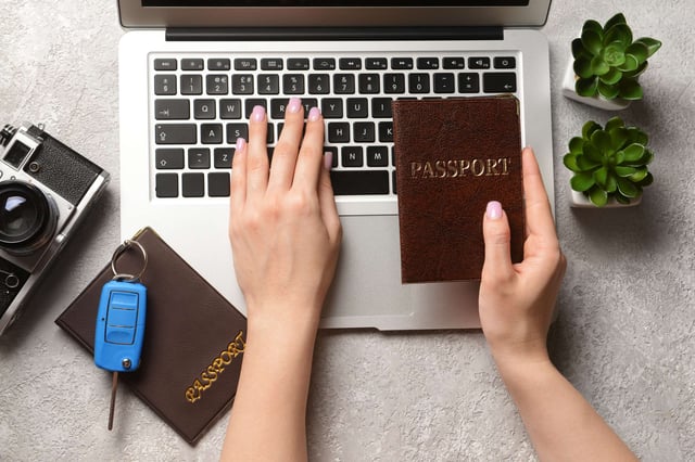 Woman With Passports Using Laptop