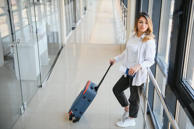 Young passenger at airport with suitcase