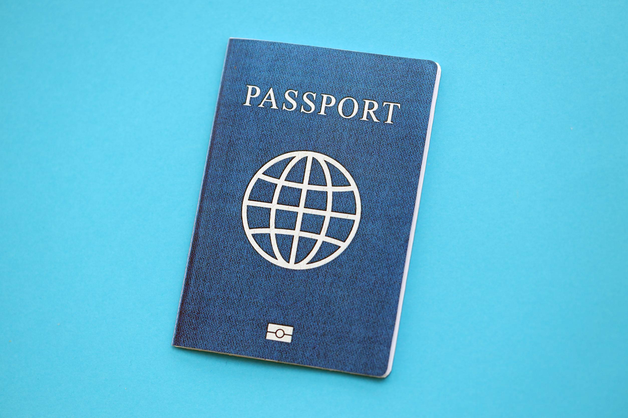 Generic Passport Book On Light Blue Paper Background Close Up