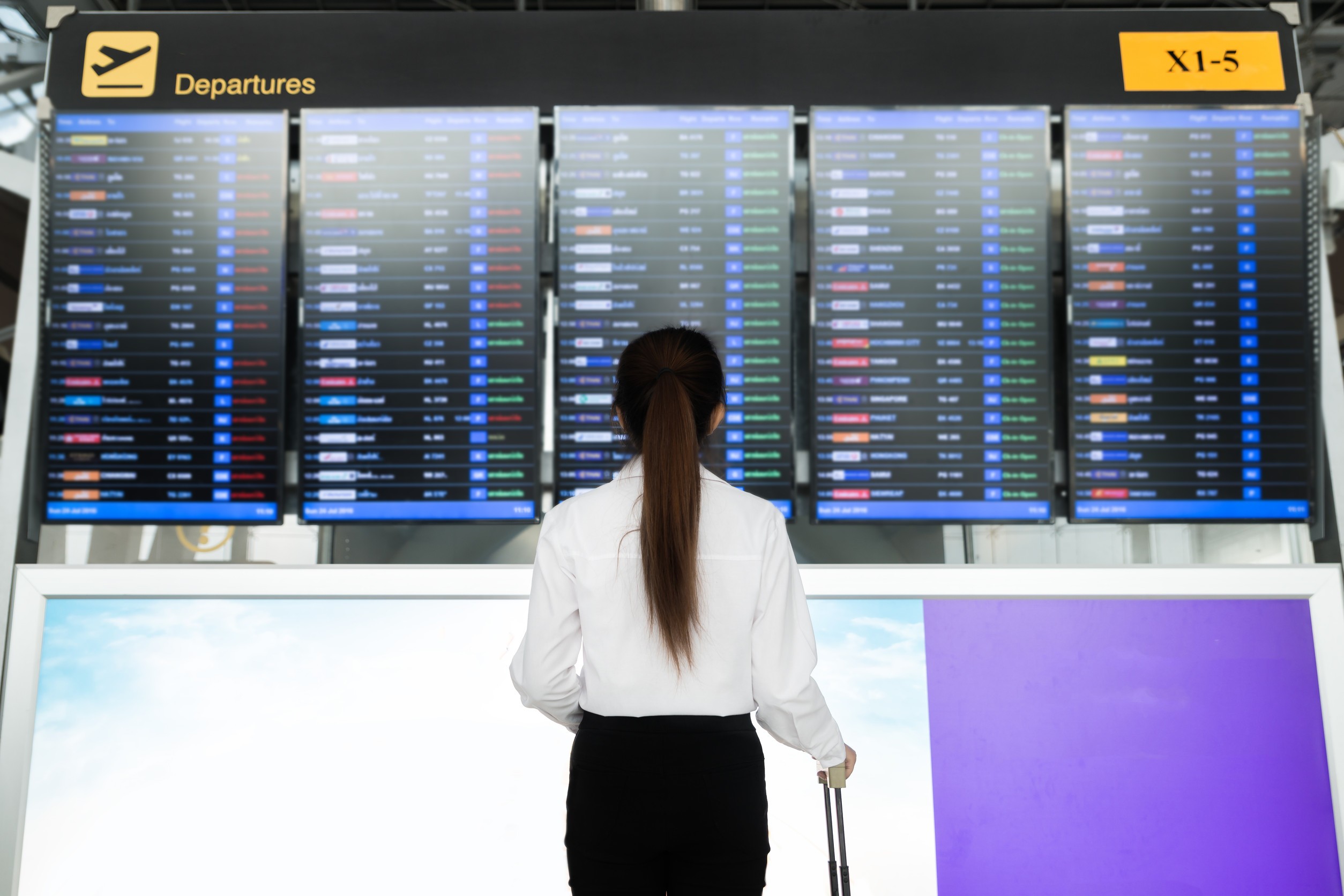 International Airport Looking At The Flight Information Board Checking